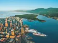 Vue aérienne de Vancouver, ville verte, avec ses gratte-ciel, son port animé et ses montagnes verdoyantes en arrière-plan.
