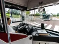Vue de l'intérieur d'un bus RATP, le conducteur porte un masque. Un autre bus approche au loin.