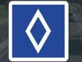 Panneau bleu avec un losange blanc. Ce panneau indique une voie réservée aux bus.