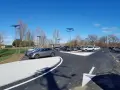 Stationnement de voitures dans une aire covoiturage Toulouse, éclairée par des lampadaires solaires sous un ciel bleu.