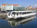 Bateau "Calais Majest'in" naviguant sur le canal. Idéal pour consulter les horaires de bus ligne 1 Calais.