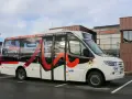 Un bus blanc avec des motifs rouges et noirs, portant l'inscription "Citéa La Navette" et des noms de localités, est garé devant un bâtiment "Valence Romans Mobilités".