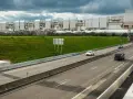 Portique de péage urbain sur une autoroute, avec des voitures passant sous les caméras.