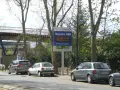 Panneau lumineux Vinci Autoroutes pour le Duplex A86, indiquant les tarifs. Des voitures sont garées sur le bord de la route.