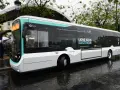 Un bus RATP bleu et blanc, "LIGNE 100% ÉLECTRIQUE", roule sur une chaussée mouillée.