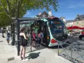 Un infobus à Vannes, avec des passagers montant à bord sous un ciel bleu.