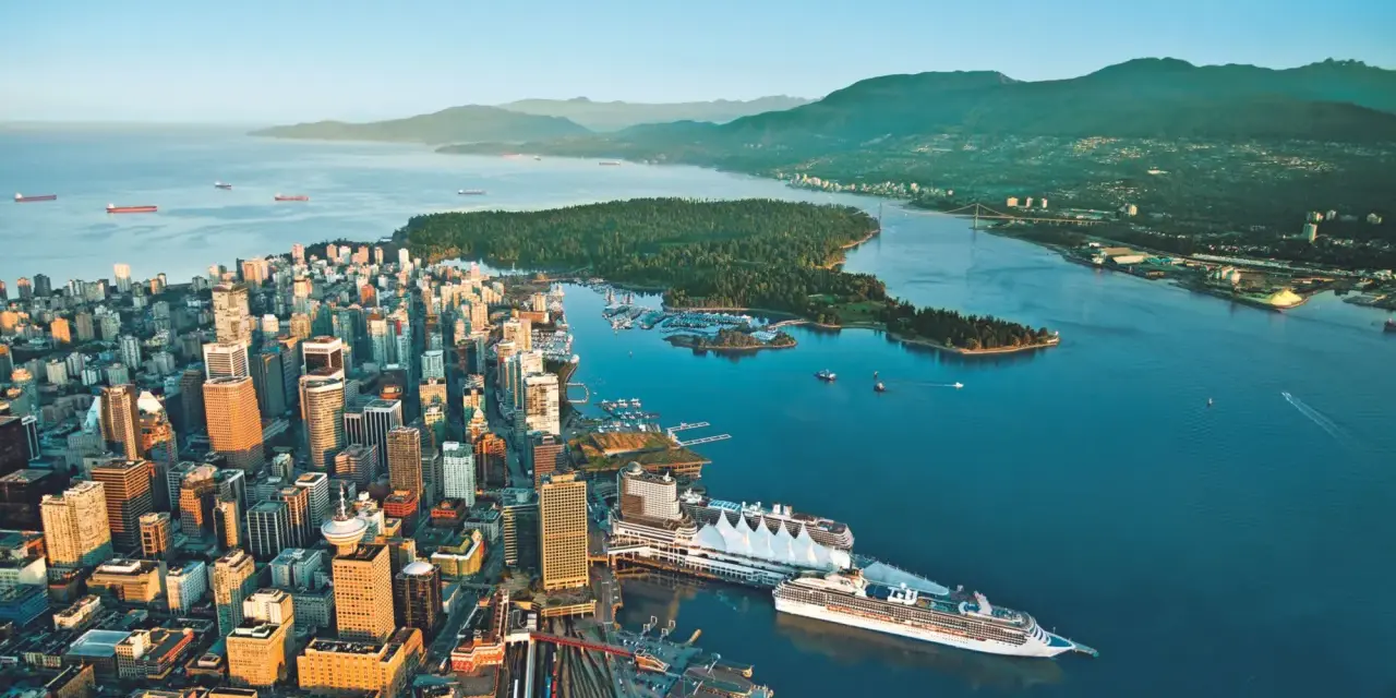 Vue aérienne de Vancouver, ville verte, avec ses gratte-ciel, son port animé et ses montagnes verdoyantes en arrière-plan.