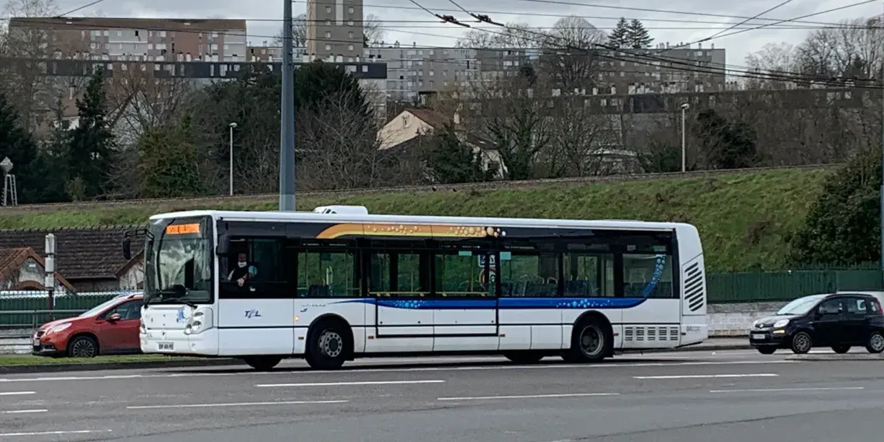 Le bus 11 de Limoges Couzeix roule sur la route, avec des immeubles en arrière-plan.