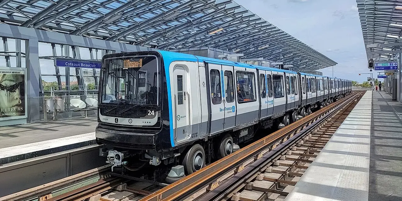 Un train de la ligne 11 du Grand Paris, direction Rosny-Bois-Perrier, s'arrête à la station Coteaux-Beauclair sous une structure moderne.