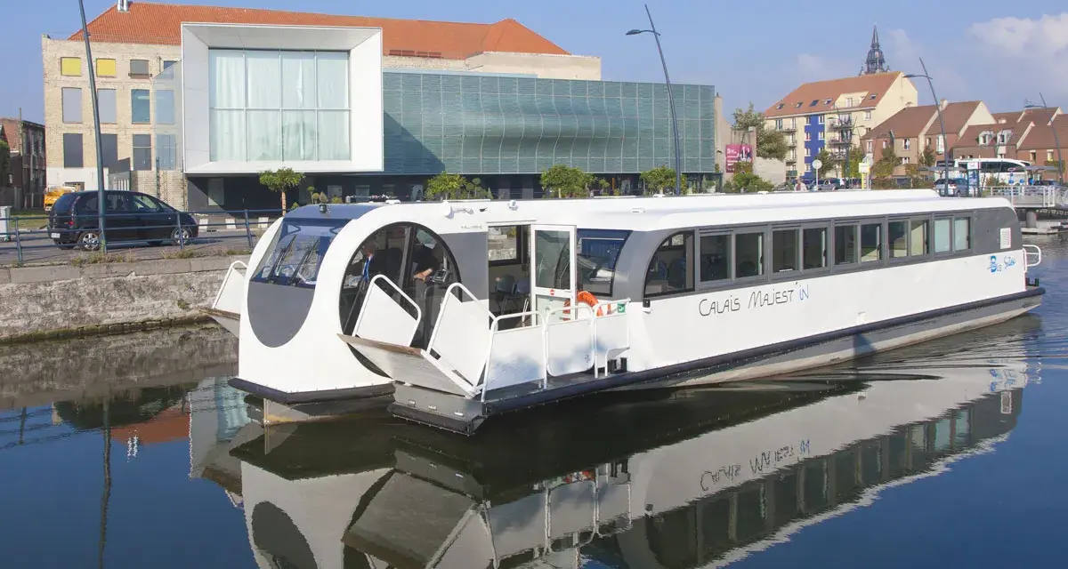 Bateau "Calais Majest'in" naviguant sur le canal. Idéal pour consulter les horaires de bus ligne 1 Calais.