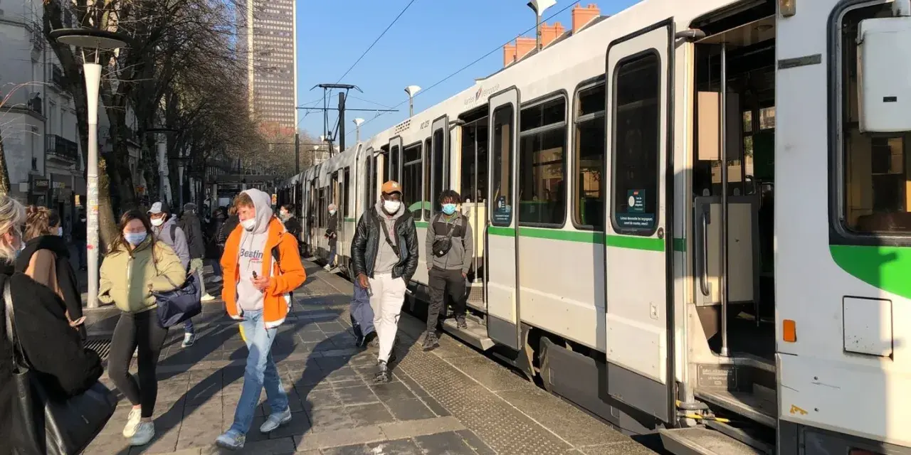 Des passagers attendent le tram à Nantes, profitant d'un week-end ensoleillé.