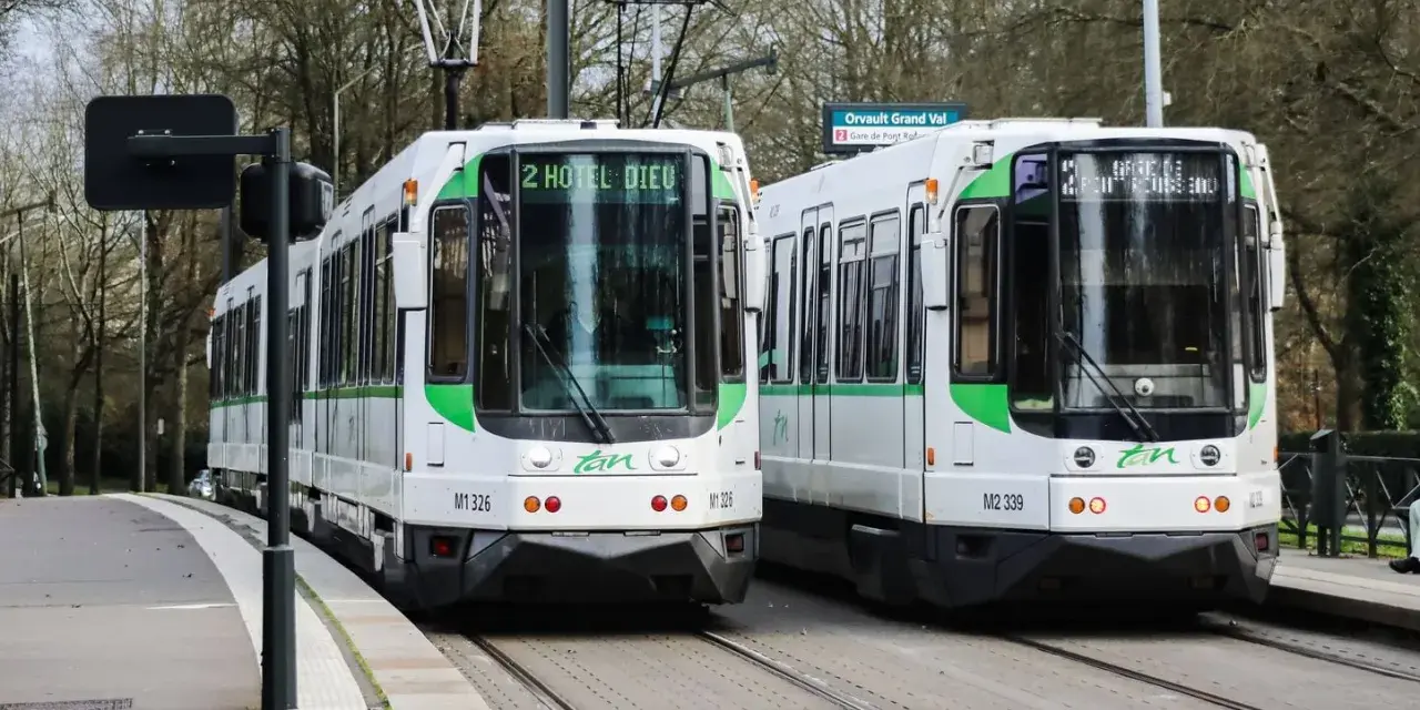 Deux trams blancs et verts de la Tan à Nantes, prêts à offrir un transport nantes gratuit. Ligne 2 vers Hôtel Dieu et Orvault Grand Val.
