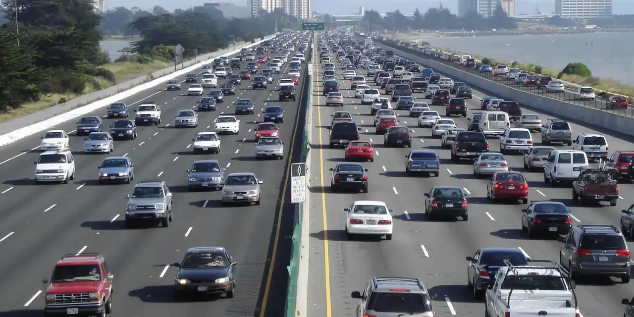 Embouteillage sur une autoroute de Los Angeles, avec des voitures sur plusieurs voies sous un ciel clair.