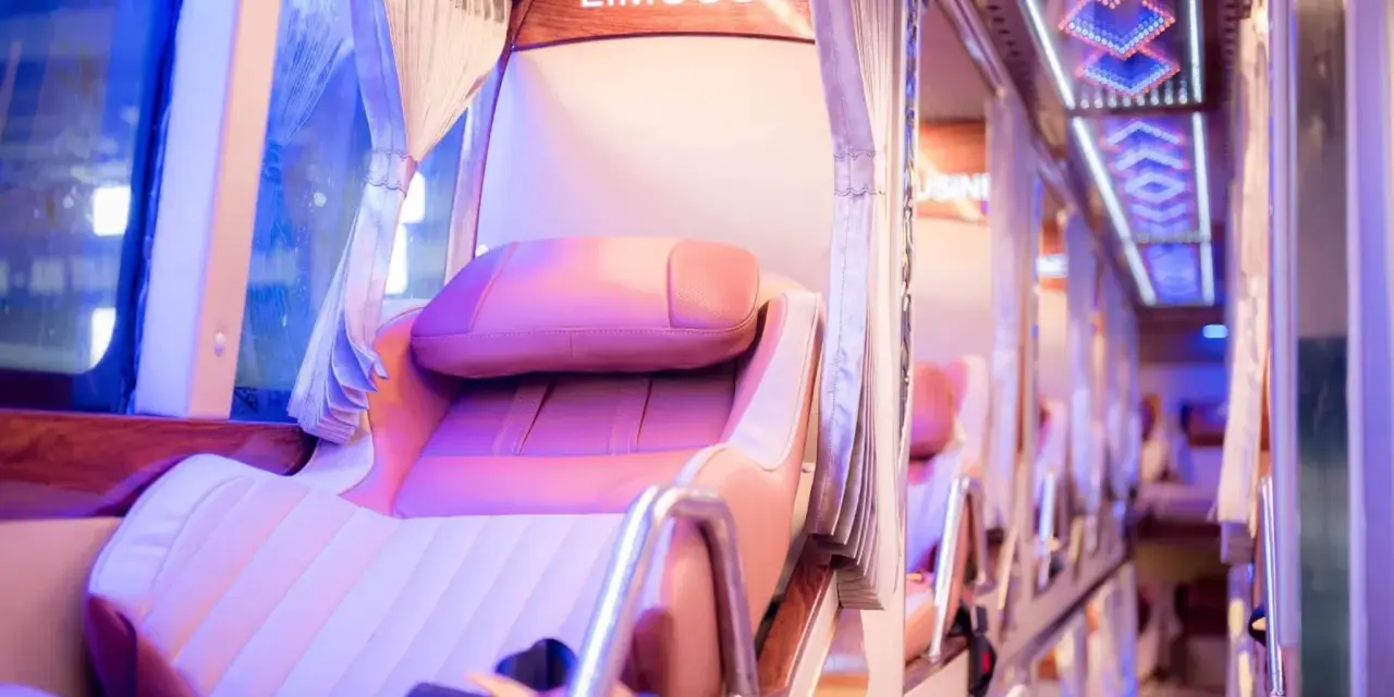 Intérieur d'un bus de luxe, avec des sièges confortables et un éclairage d'ambiance. Le mot "LIMOUSIN" est visible.