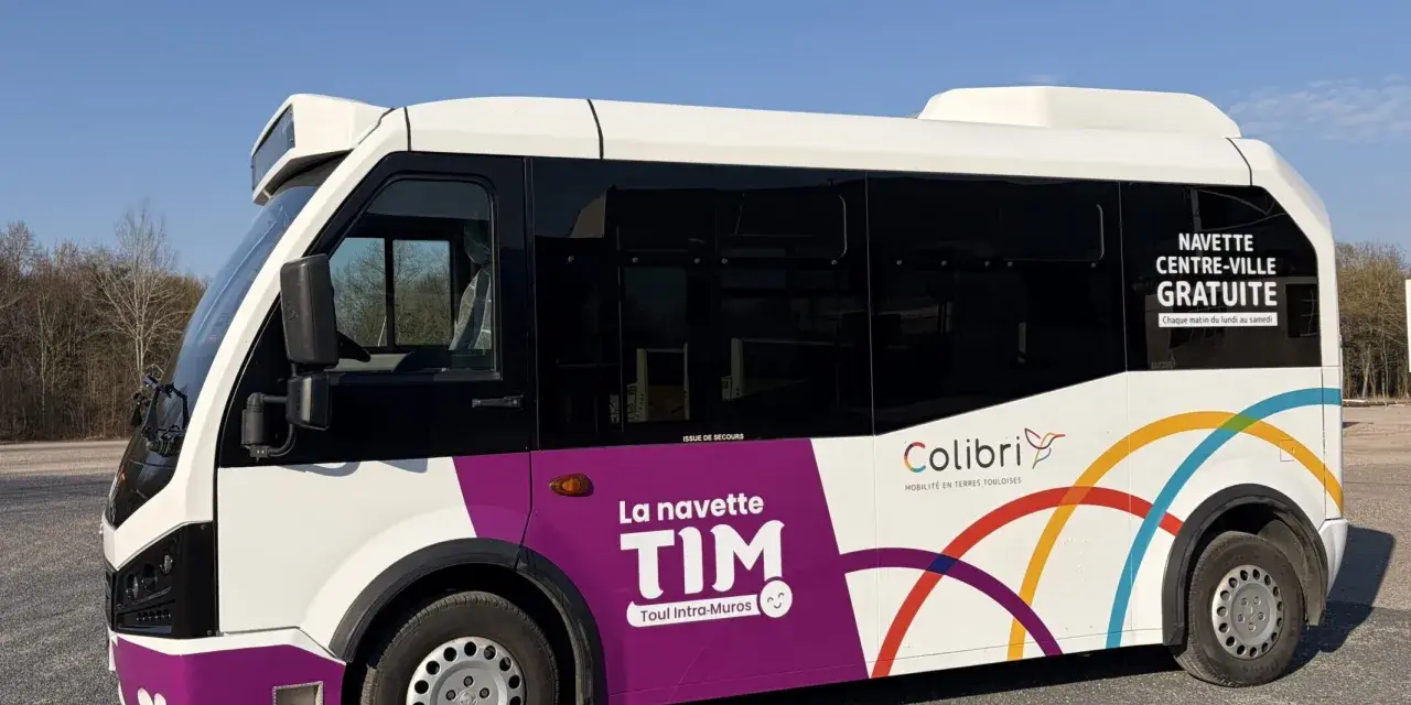 Le bus TIM, navette gratuite de Toul Intra-Muros, roule sous un ciel bleu.