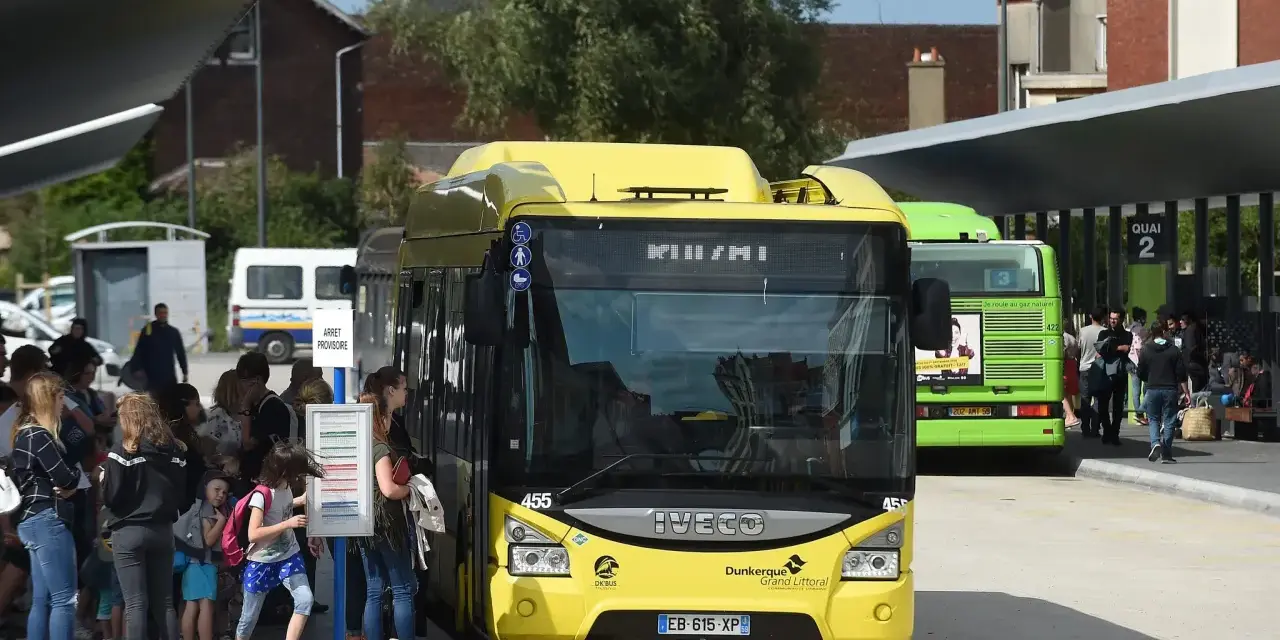 Des bus jaunes et verts attendent des passagers. Une affiche sur le bus vert mentionne "100% GRATUIT", illustrant la gratuité des transports en commun.