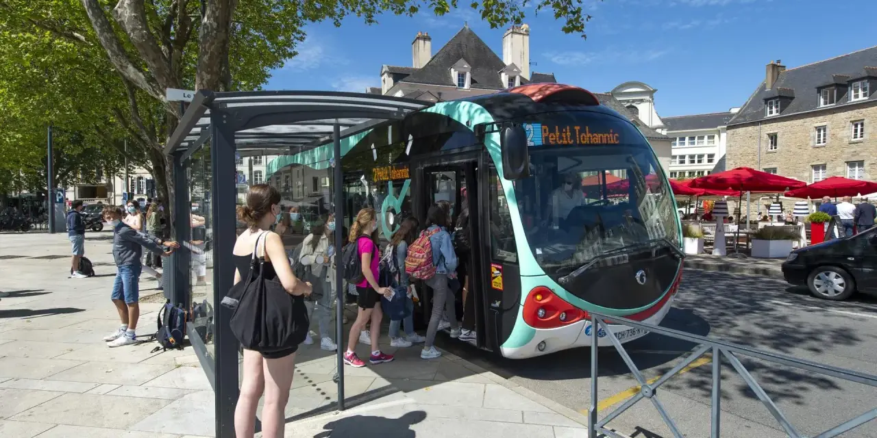 Un infobus à Vannes, avec des passagers montant à bord sous un ciel bleu.