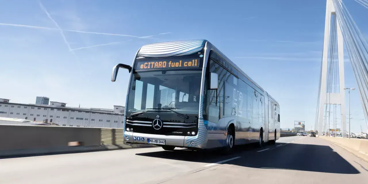 eCitaro fuel cell, un bus articulé futuriste, roule sur une autoroute sous un ciel bleu. Sa fiche technique promet une mobilité propre.