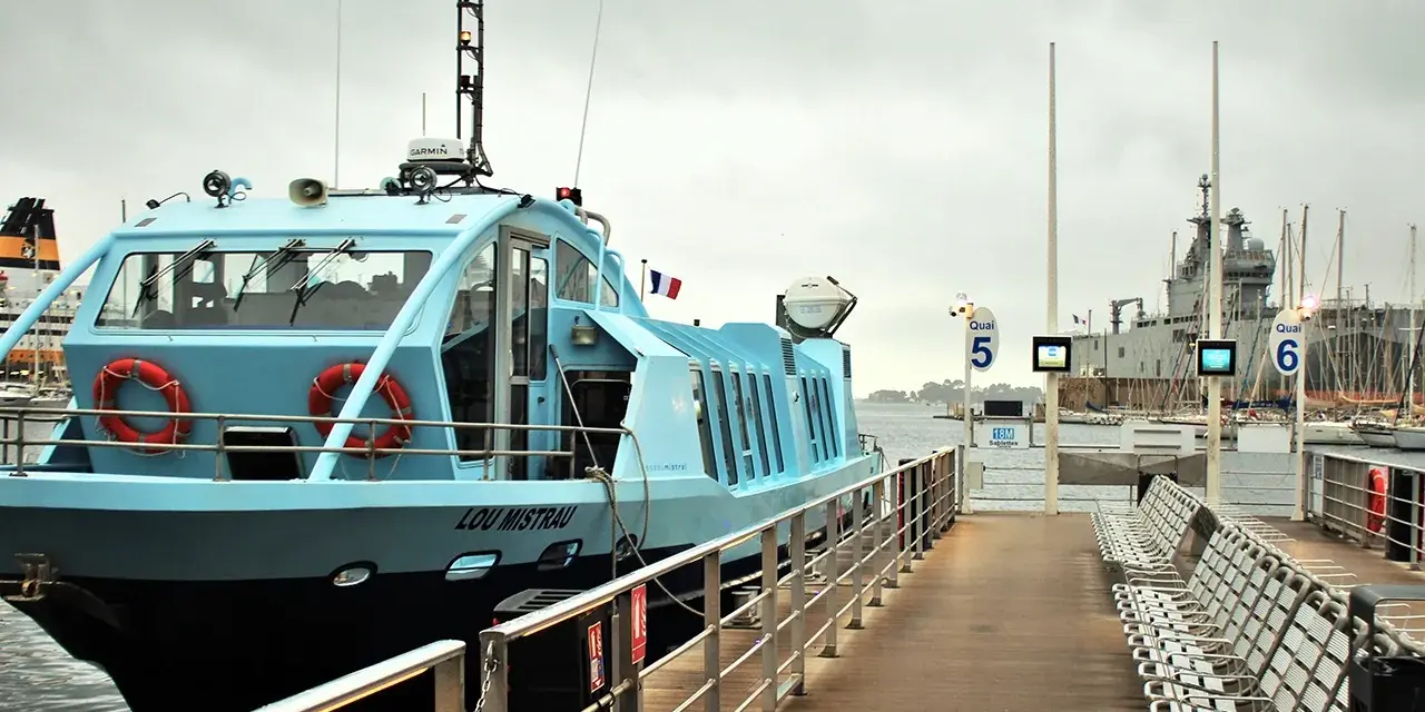 Le bateau "Lou Mistral" est amarré à quai, prêt à embarquer des passagers. Le **réseau Mistral** dessert cette ligne maritime.