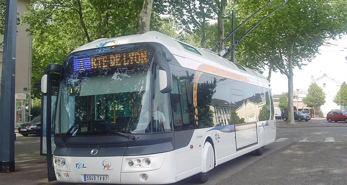Trolleybus blanc à Lyon, prêt à partir. Les perches électriques sont visibles sur le toit.