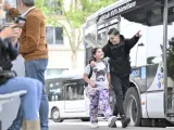 Un jeune homme et une fillette souriants marchent près d'un bus Transdev à Blois.
