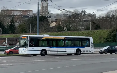 Le bus 11 de Limoges Couzeix roule sur la route, avec des immeubles en arrière-plan.