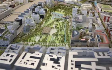 Maquette d'une opération d'aménagement urbain avec bâtiments modernes, espaces verts et un plan d'eau.