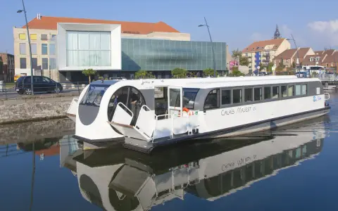 Bateau "Calais Majest'in" naviguant sur le canal. Idéal pour consulter les horaires de bus ligne 1 Calais.