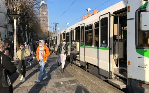 Des passagers attendent le tram à Nantes, profitant d'un week-end ensoleillé.