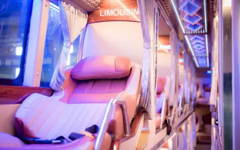 Intérieur d'un bus de luxe, avec des sièges confortables et un éclairage d'ambiance. Le mot "LIMOUSIN" est visible.