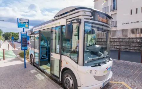 Un bus moderne, un trainbus, attend à un arrêt à Saint-Cyprien, prêt à emmener les passagers pour une transition écologique.