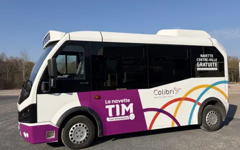 Le bus TIM, navette gratuite de Toul Intra-Muros, roule sous un ciel bleu.
