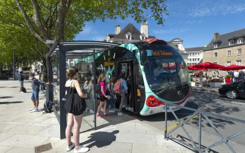 Un infobus à Vannes, avec des passagers montant à bord sous un ciel bleu.
