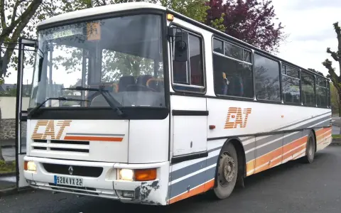Un bus Karosa Recreo blanc avec des rayures grises et oranges, prêt pour une nouvelle aventure.