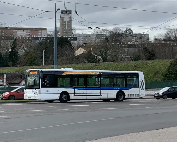 Le bus 11 de Limoges Couzeix roule sur la route, avec des immeubles en arrière-plan.