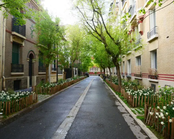 Rue pavillonnaire bordée d'arbres et de fleurs, la voirie est propre et accueillante.