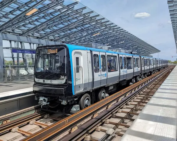 Un train de la ligne 11 du Grand Paris, direction Rosny-Bois-Perrier, s'arrête à la station Coteaux-Beauclair sous une structure moderne.