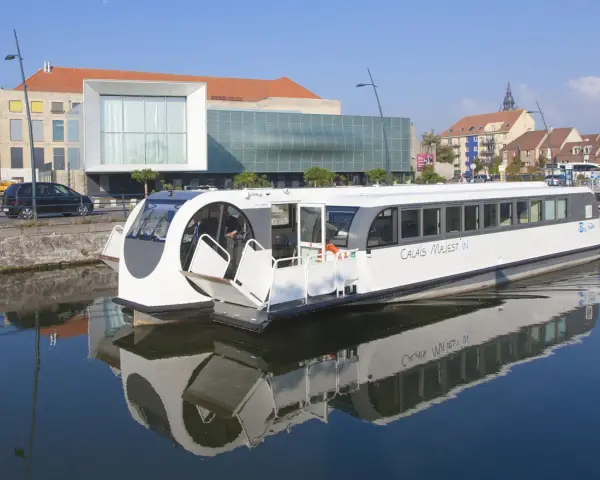 Bateau "Calais Majest'in" naviguant sur le canal. Idéal pour consulter les horaires de bus ligne 1 Calais.