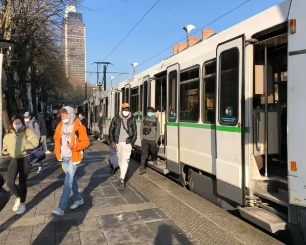 Des passagers attendent le tram à Nantes, profitant d'un week-end ensoleillé.