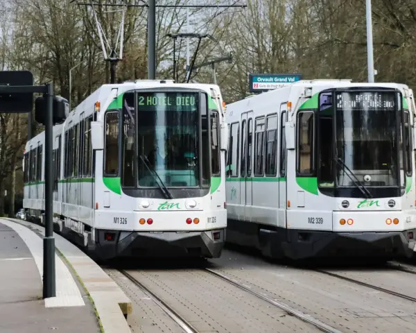 Deux trams blancs et verts de la Tan à Nantes, prêts à offrir un transport nantes gratuit. Ligne 2 vers Hôtel Dieu et Orvault Grand Val.