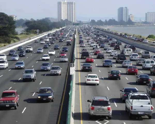 Embouteillage sur une autoroute de Los Angeles, avec des voitures sur plusieurs voies sous un ciel clair.