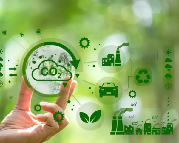 Main d'une personne tenant une sphère symbolisant la Terre et le CO2, entourée d'icônes représentant l'industrie, le transport et le recyclage, illustrant la transformation des territoires vers un avenir durable.