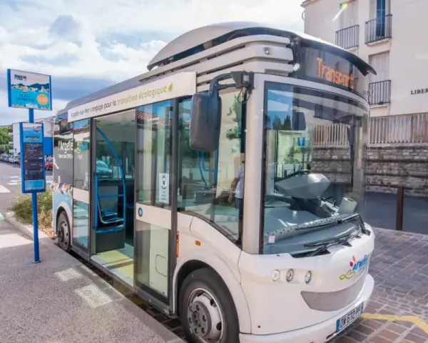 Un bus moderne, un trainbus, attend à un arrêt à Saint-Cyprien, prêt à emmener les passagers pour une transition écologique.