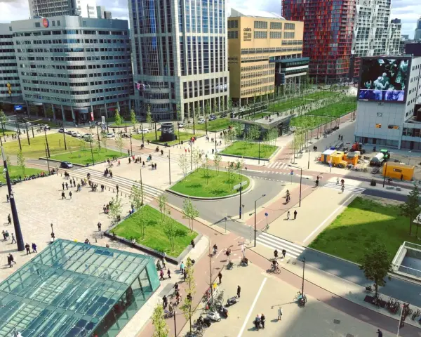 Une **couronne urbaine** animée avec des bâtiments modernes, des espaces verts et des passants.