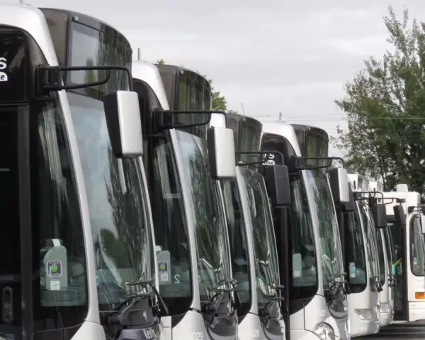 Une rangée de bus Keolis Val d'Oise stationnés, prêts pour le transport.