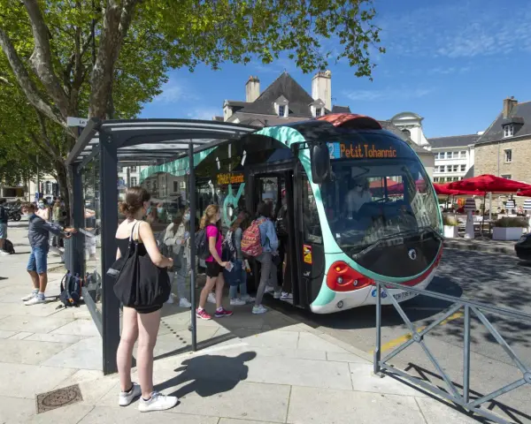 Un infobus à Vannes, avec des passagers montant à bord sous un ciel bleu.