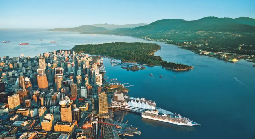Vue aérienne de Vancouver, ville verte, avec ses gratte-ciel, son port animé et ses montagnes verdoyantes en arrière-plan.