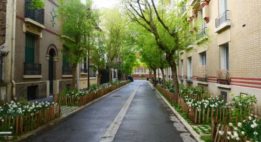 Rue pavillonnaire bordée d'arbres et de fleurs, la voirie est propre et accueillante.