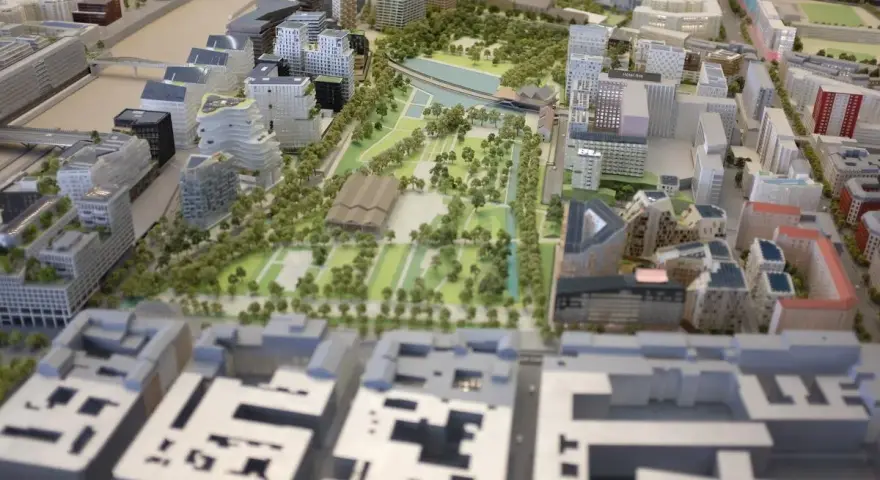 Maquette d'une opération d'aménagement urbain avec bâtiments modernes, espaces verts et un plan d'eau.