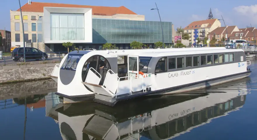 Bateau "Calais Majest'in" naviguant sur le canal. Idéal pour consulter les horaires de bus ligne 1 Calais.